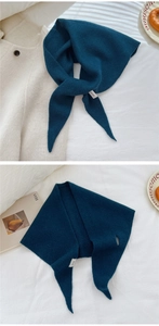 Dettaglio della sciarpa in maglia blu pavone con etichetta 100 percento lana e trama soffice