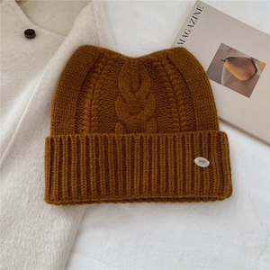 Détail d'un bonnet tricoté en laine à oreilles de chat avec texture torsadée épaisse