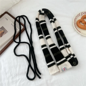 Detailed close-up of knit texture and woven label on a striped winter scarf