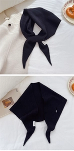 Dettaglio di una sciarpa in maglia 100% lana nera con pratica chiusura a fessura