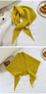 Dettaglio di sciarpa in lana gialla a maglia con texture e fessura di fissaggio