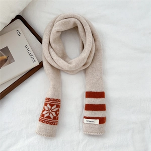Detail of 100% wool beige striped scarf with snowflake pattern and material label