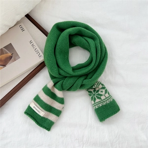 Detail of green and white wool scarf with snowflake jacquard and striped knit pattern
