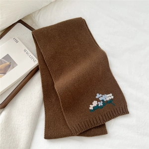 Close-up of mocha brown knit wool scarf featuring delicate floral embroidery detail