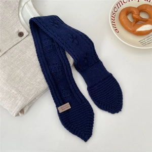 Detail of navy knit wool scarf with 100% wool label and textured relief pattern