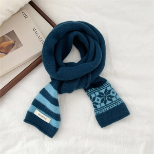 Close-up of wool scarf showing blue stripes and snowflake jacquard with 100% wool label
