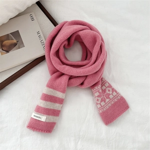 Detailed view of pink 100% wool striped scarf with Nordic jacquard on white fabric