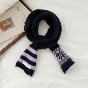 Detail of 100% wool knitted scarf with snowflake patterns and quality care label