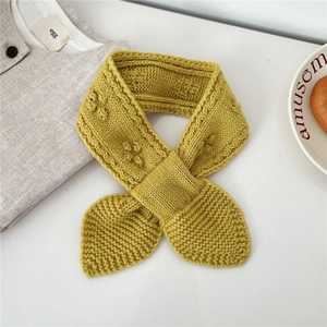 Detail of mustard yellow chunky knit scarf with leaf-shaped ends and soft texture