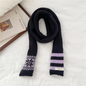 Close-up of 100% wool knitted scarf with purple snowflake patterns and stripes