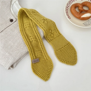 Close-up of mustard yellow knitted wool scarf with textured weave on white background