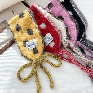 Close-up of soft knitted polka dot scarves with vintage brand labels in vibrant colors