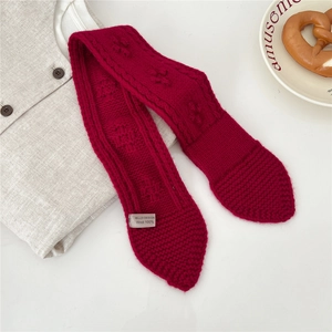 Detail of 100% wool knitted scarf with embossed pattern and branded woven label