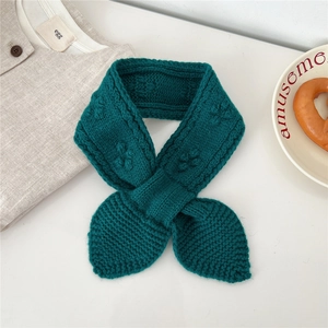 Detailed close-up of dark green knitted wool scarf with intricate cable stitch texture