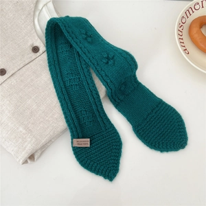 Detail of 100% wool chunky knit scarf in dark green with thick cable pattern texture