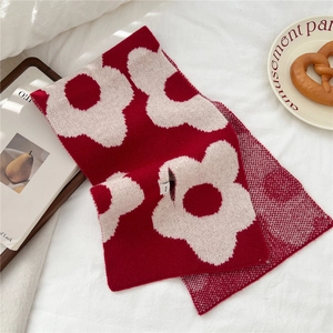 Detail of red and white floral knit wool scarf with soft texture for winter comfort