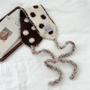 Close-up of knit polka dot scarf with brown wool texture and woven brand label