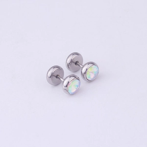 Macro shot of silver stainless steel dumbbell earrings featuring inset iridescent opals