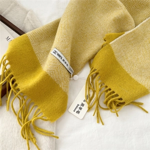 Detail of premium lambswool scarf with ginger herringbone pattern and soft fringe finish