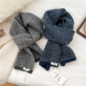 Detail of soft knitted scarves with white wavy ripples and ZPKR woven brand labels
