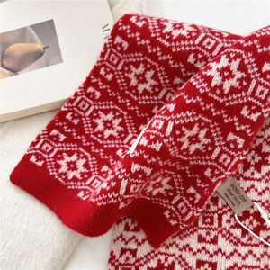 Detailed close-up showing 100% pure wool texture and red jacquard pattern on the scarf