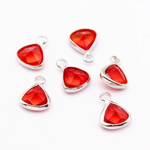 Detailed view of six red triangle crystal charms with silver metal edges and top loops