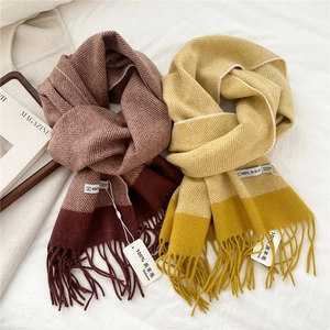 Detail of 100% lambswool scarves with herringbone pattern and fringe in red and yellow