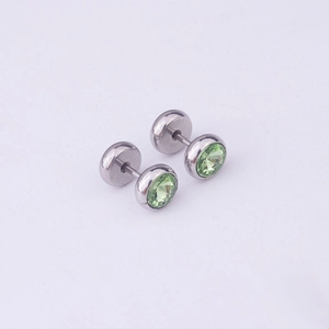 Detail of silver stainless steel dumbbell earrings with round light green crystals