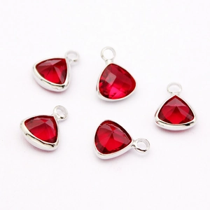 Macro shot of five red faceted teardrop crystal pendants with silver metal bases and loops