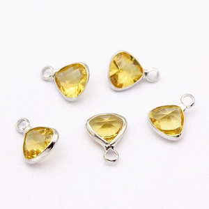 Detail of five yellow triangular faceted crystal pendants with silver metal frames