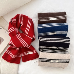 Close-up of multicolored striped wool scarves with 100% wool label on textured fabric
