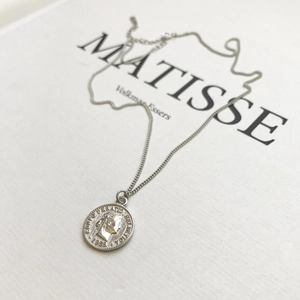 Detailed close-up of a 925 sterling silver vintage coin pendant on a delicate chain