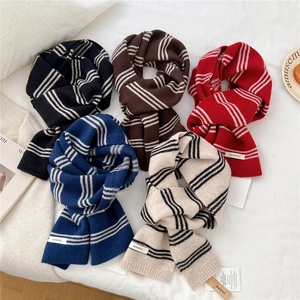 Striped wool knit scarves in five colors displayed on a white textured background