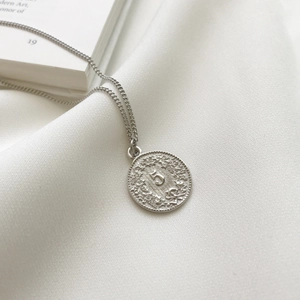 Macro shot of 925 sterling silver dollar coin pendant with embossed number 5 detail