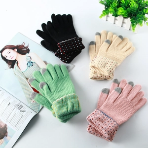 Gros plan de gants en tricot avec poignets à fleurs et bouts de doigts tactiles