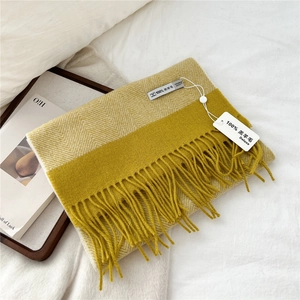 Detail of yellow and white herringbone wool scarf with dense long tassel fringe