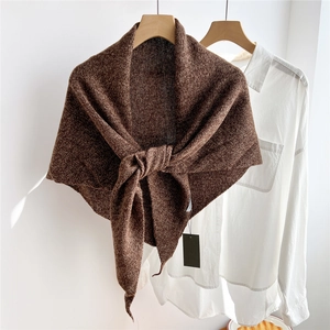 Close-up of dark coffee knit wool triangle scarf draped over a minimal white shirt