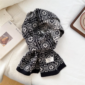 Detail of wool knit scarf featuring Nordic snowflake patterns and authentic wool label