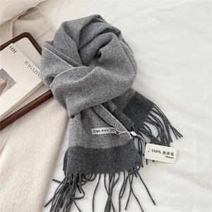 Detailed texture of grey herringbone lambswool scarf featuring soft fringe edges
