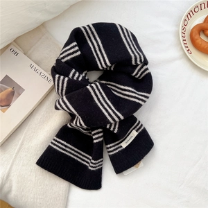 Detailed macro view of 100% wool label on a black and white striped knitted scarf