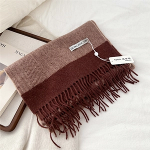 Detail of 100% lamb wool scarf showing herringbone weave texture and long tassels
