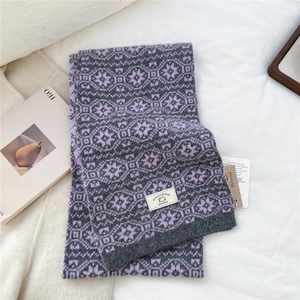 Close-up of wool scarf showing the purple snowflake knit texture and 100% wool label