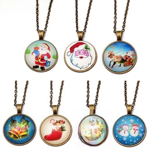 Detail of Christmas themed glass pendants on bronze chains with festive holiday illustrations
