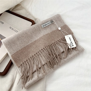 Detail of 100% lamb wool scarf showing herringbone weave and delicate fringe texture