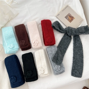 Colorful mohair knit scarf collection with 3D crochet flowers on a white fabric background