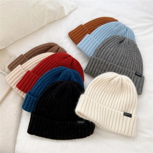 Detail shot of multi-colored wool knit beanies with ribbed texture and folded cuff