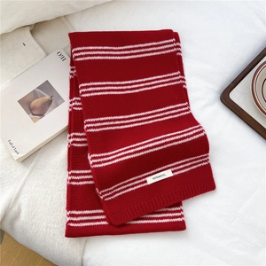 Detailed close-up of a red and white striped 100% wool knitted scarf with ribbed ends