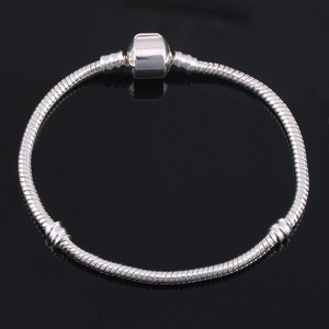 S925 silver snake chain bracelet with barrel clasp on a black mirror surface