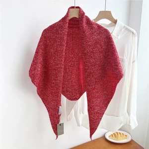 Detail view of red and white knit wool shawl texture with laundry tags and hangtags