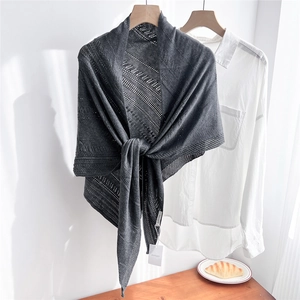 Detail of dark grey knitted shawl with delicate openwork pattern over a white shirt